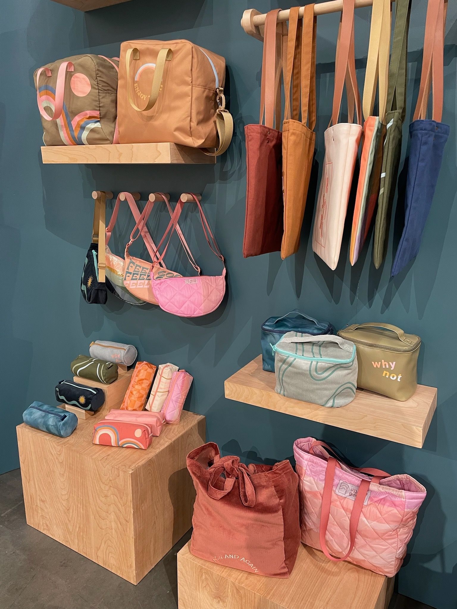 A display of bags and umbrellas on shelves in a store.