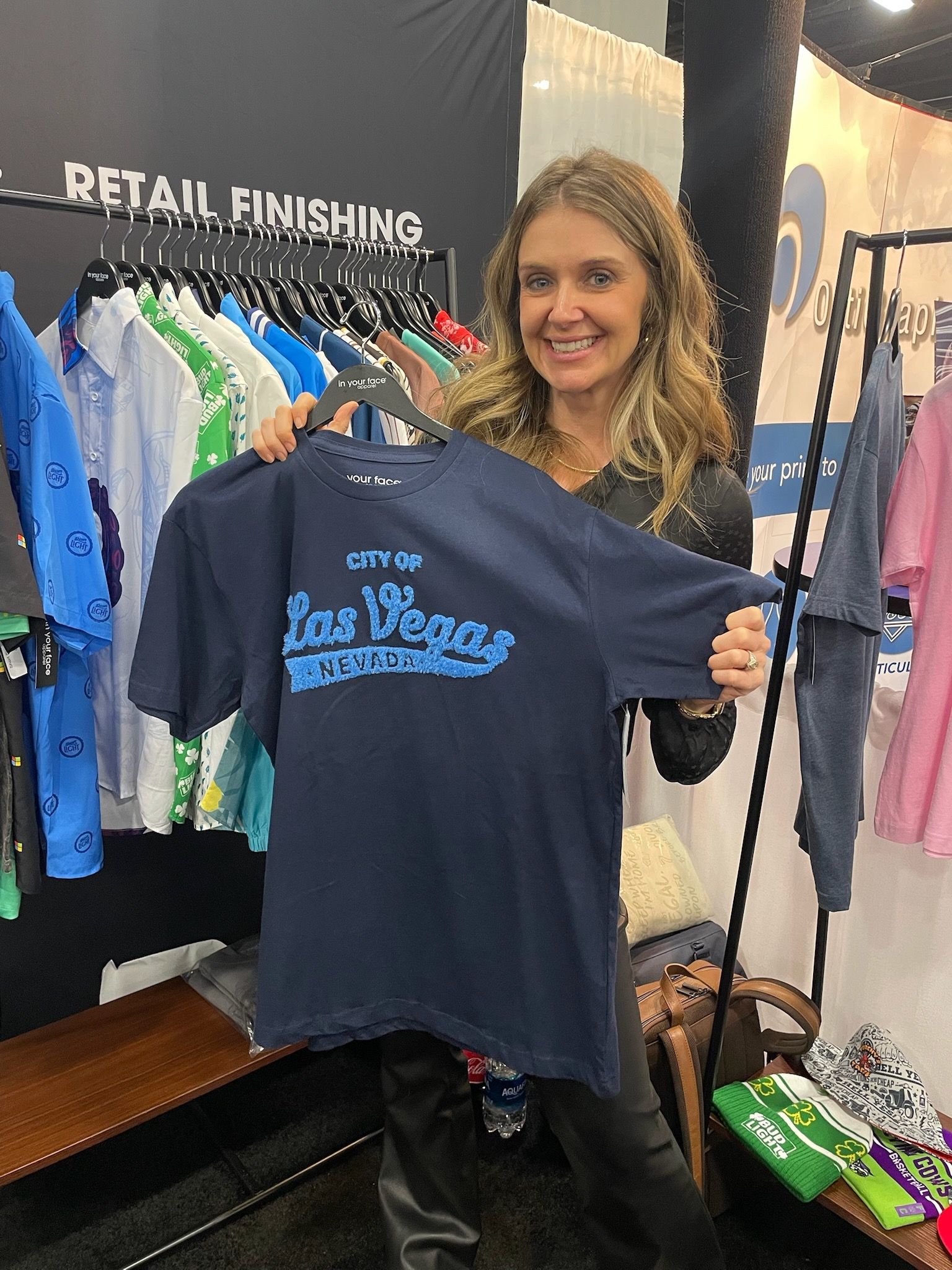 A woman is holding a blue t-shirt that says las vegas on it.