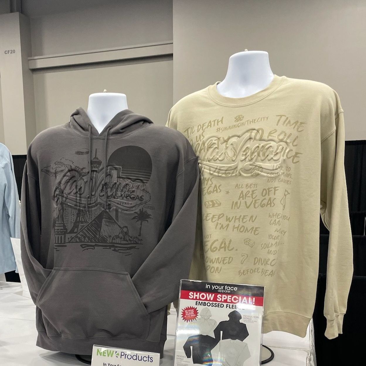A hoodie and a sweatshirt are on display on mannequins in a store.