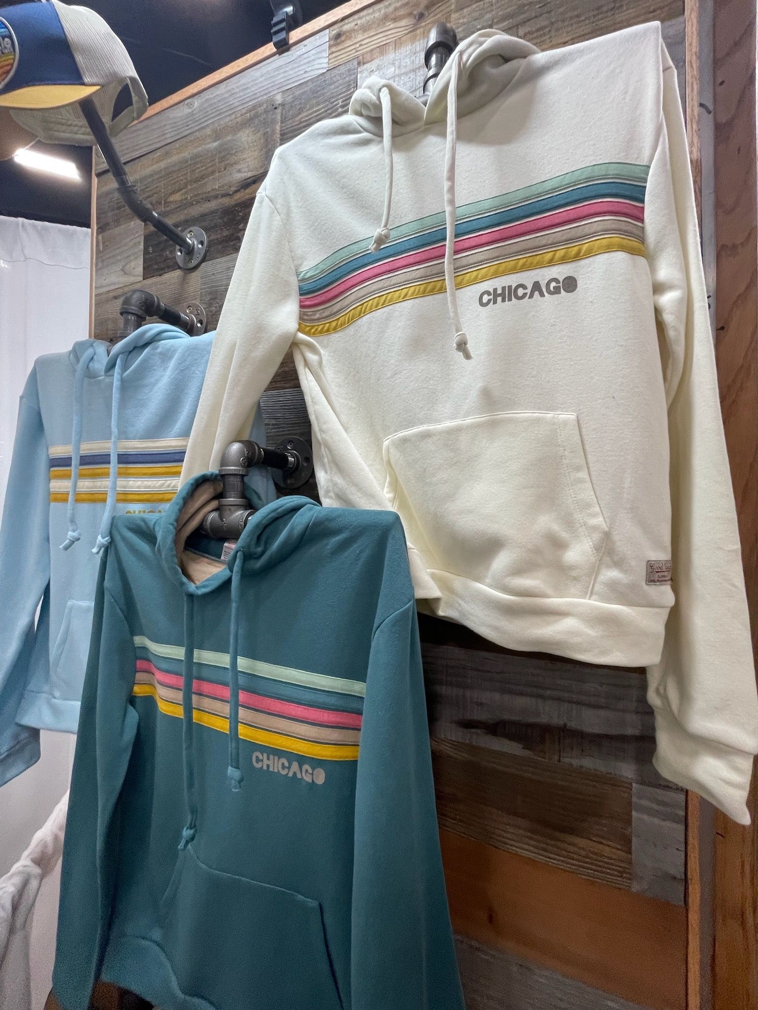 A row of hoodies hanging on a rack in a store.