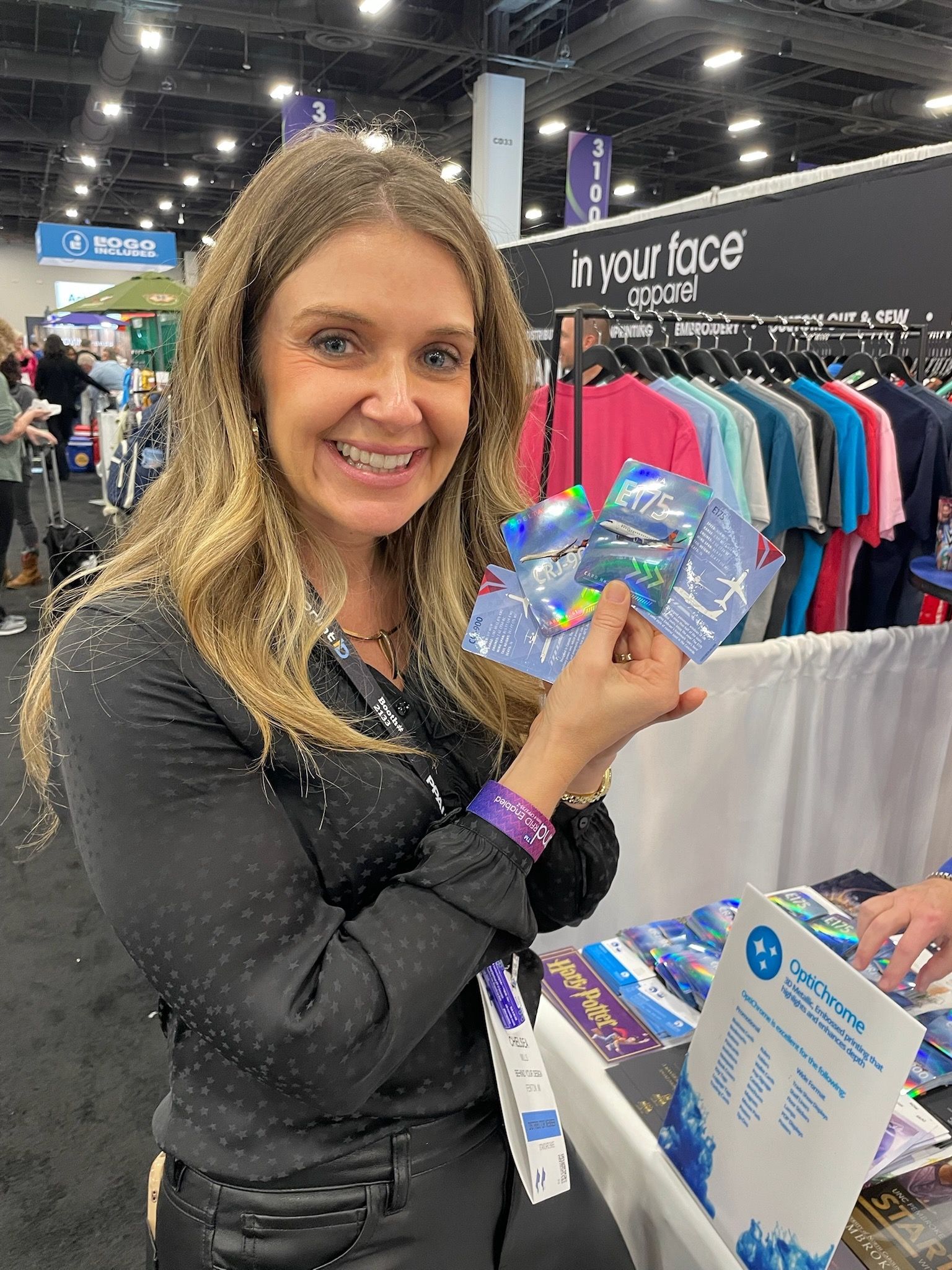 A woman is holding a cd in her hand at a convention.