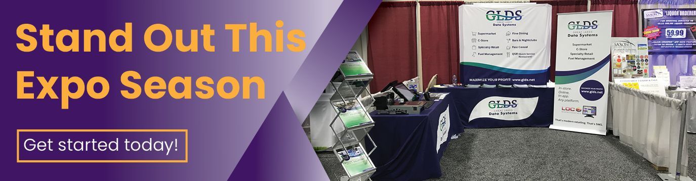 Purple trade show banner reading “Stand Out This Expo Season” beside product display booths