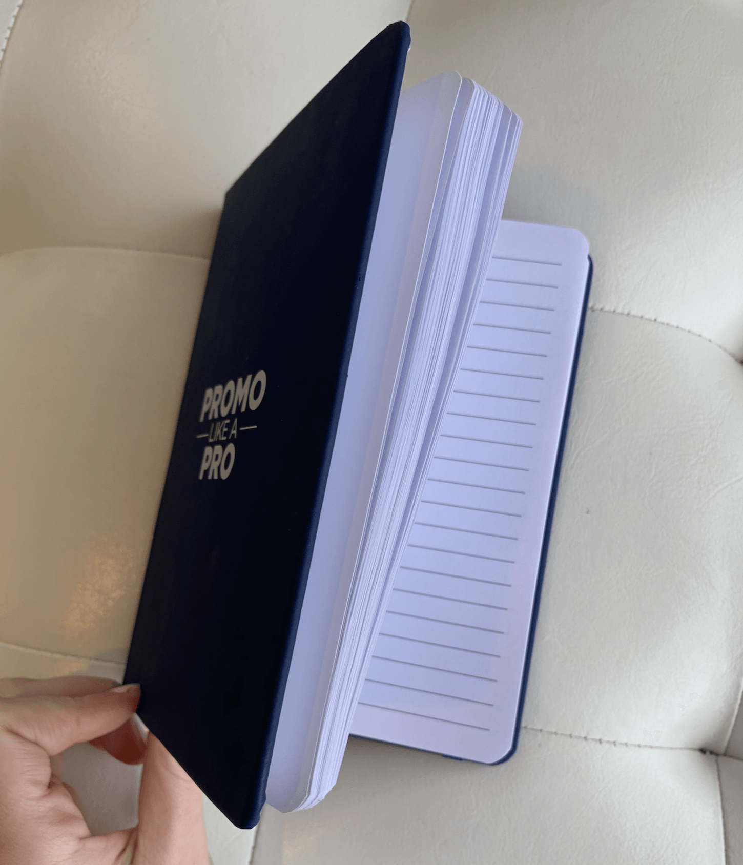 A person is holding a notebook that says promo pro