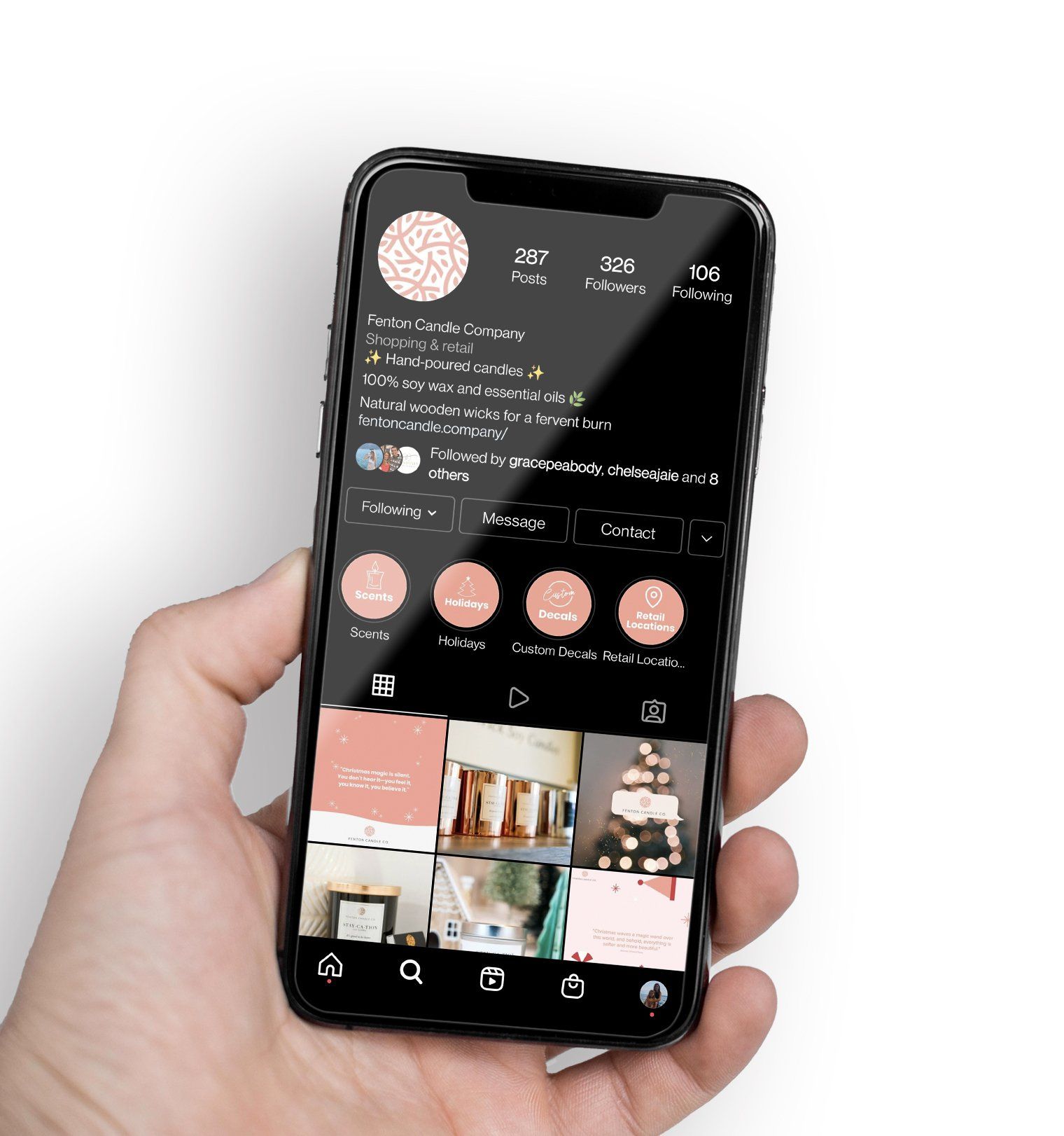 Hand holding a smartphone showing a dark-themed social media profile page with photo grid