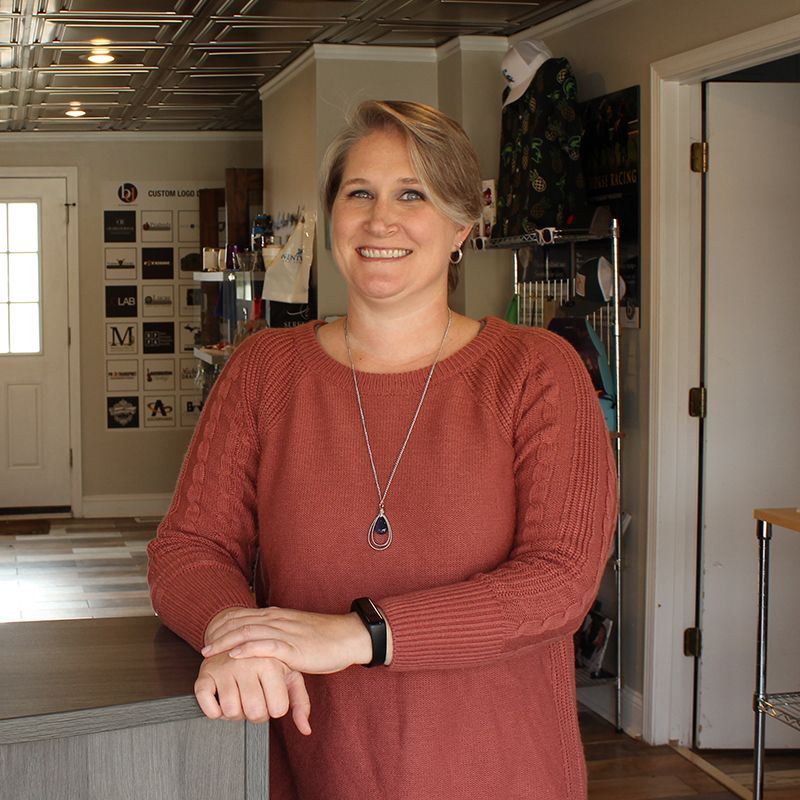 A woman in a red sweater is standing in a kitchen