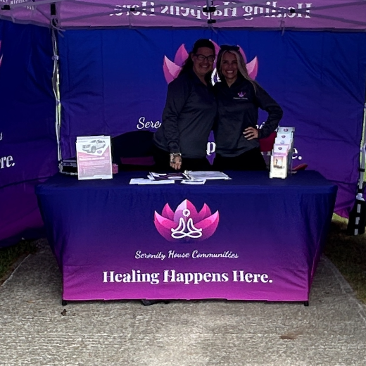 Two people standing behind a table that says healing happens here