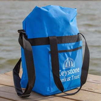 Blue Keystone Bank & Trust drawstring bag on a wooden table outdoors.