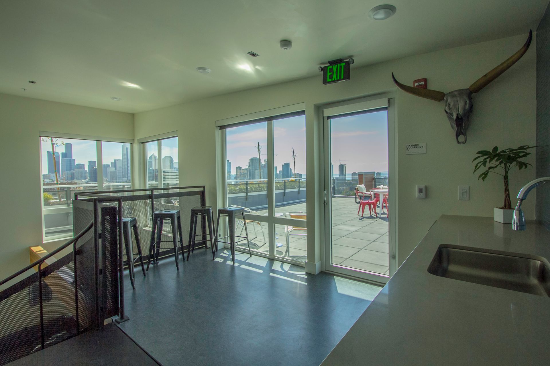 Bright room with glass doors, city view, counter, and wall-mounted bull skull decor