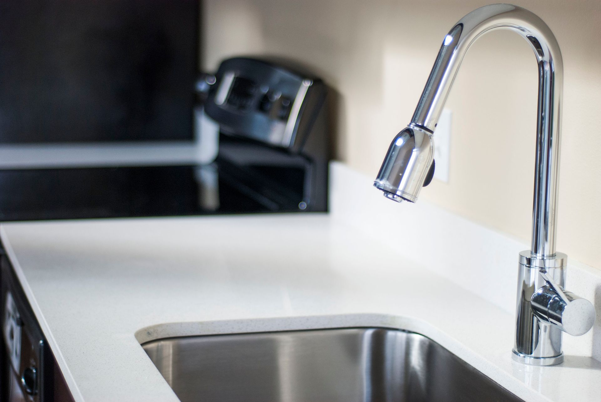 Modern kitchen sink with chrome faucet and white countertop