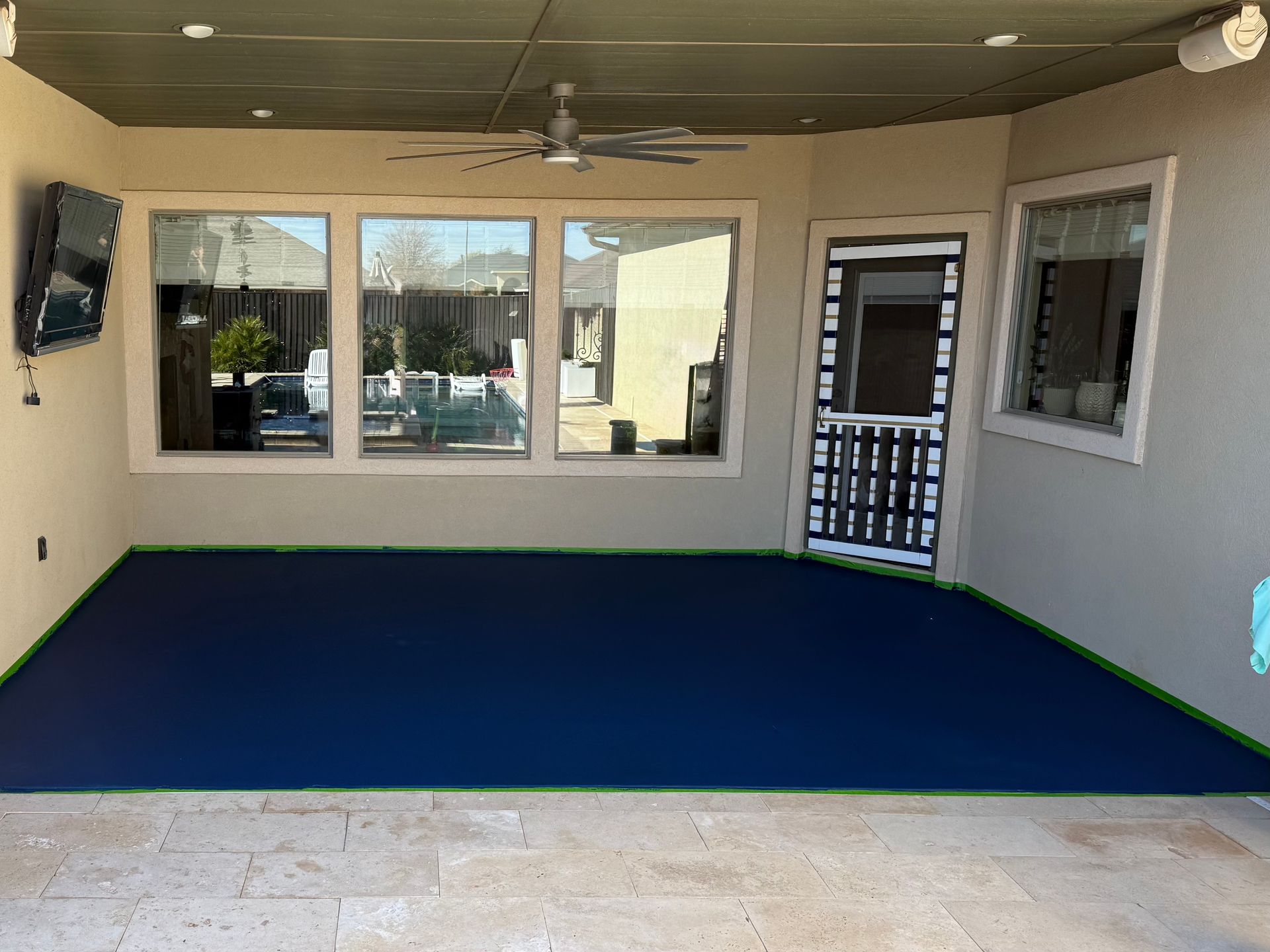 Outdoor patio with blue painted floor, windows, and a door.