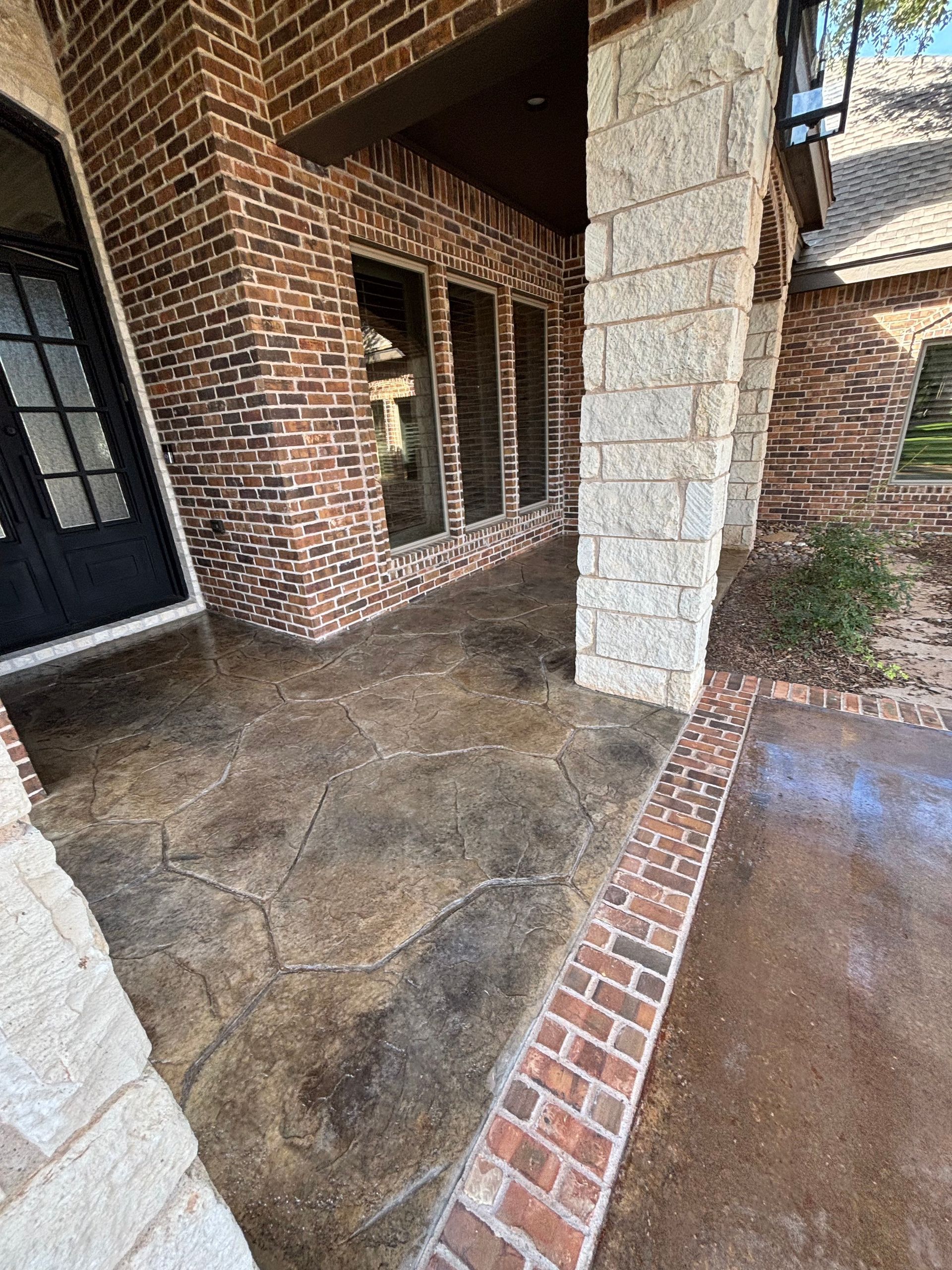 Brick and stone exterior with stamped concrete porch.