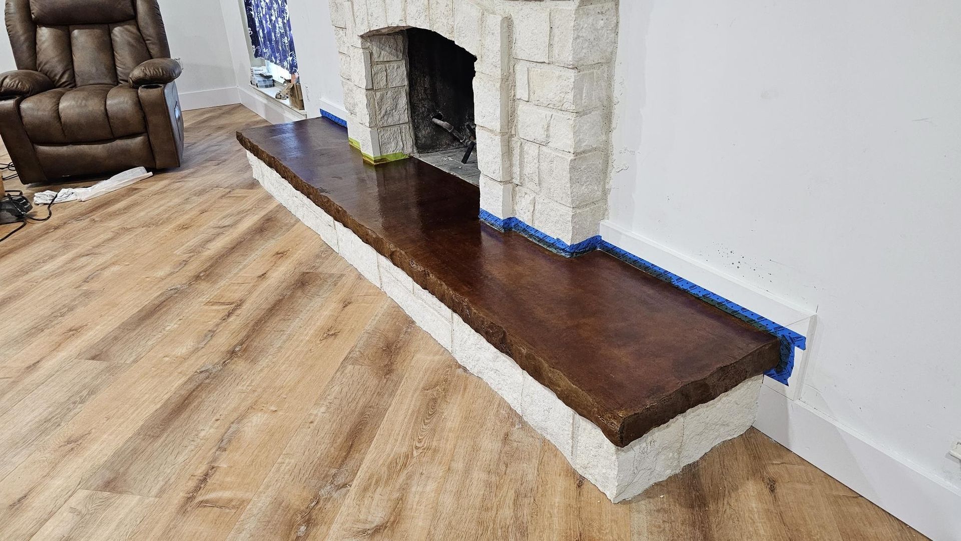 Fireplace with brown wooden mantle and white brick surround; installed on wooden floor.