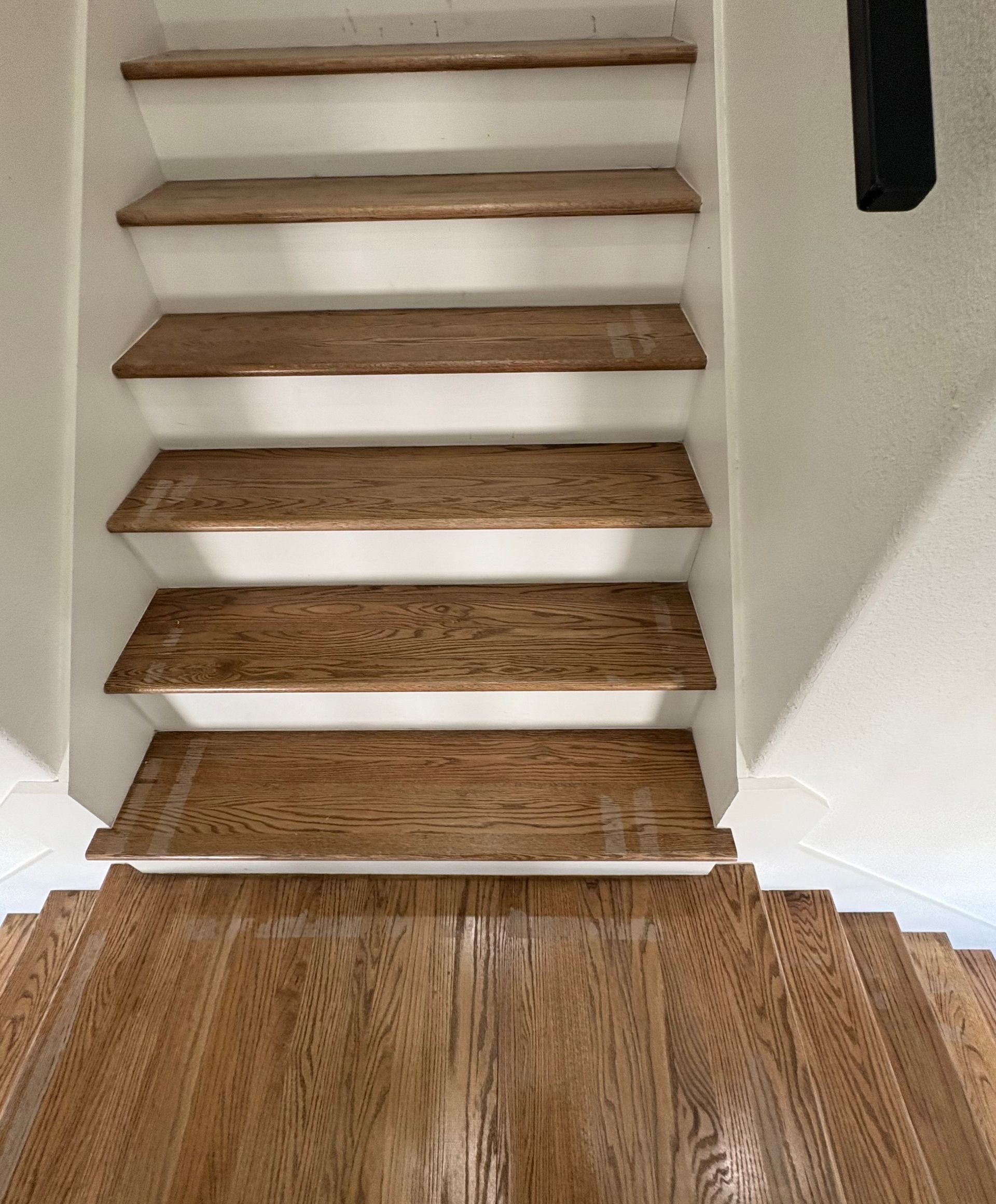 Wooden staircase with light brown treads and white risers.