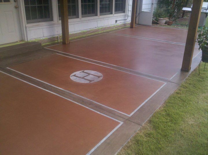 Brown stained concrete patio with white border and central access point.