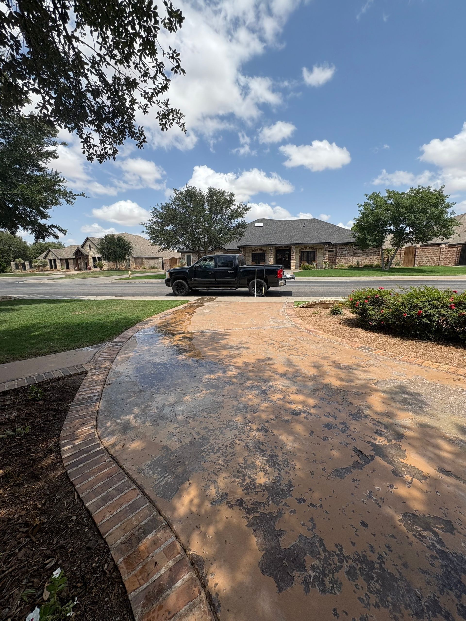 A black pickup truck parked on a street in a suburban neighborhood on a sunny day.