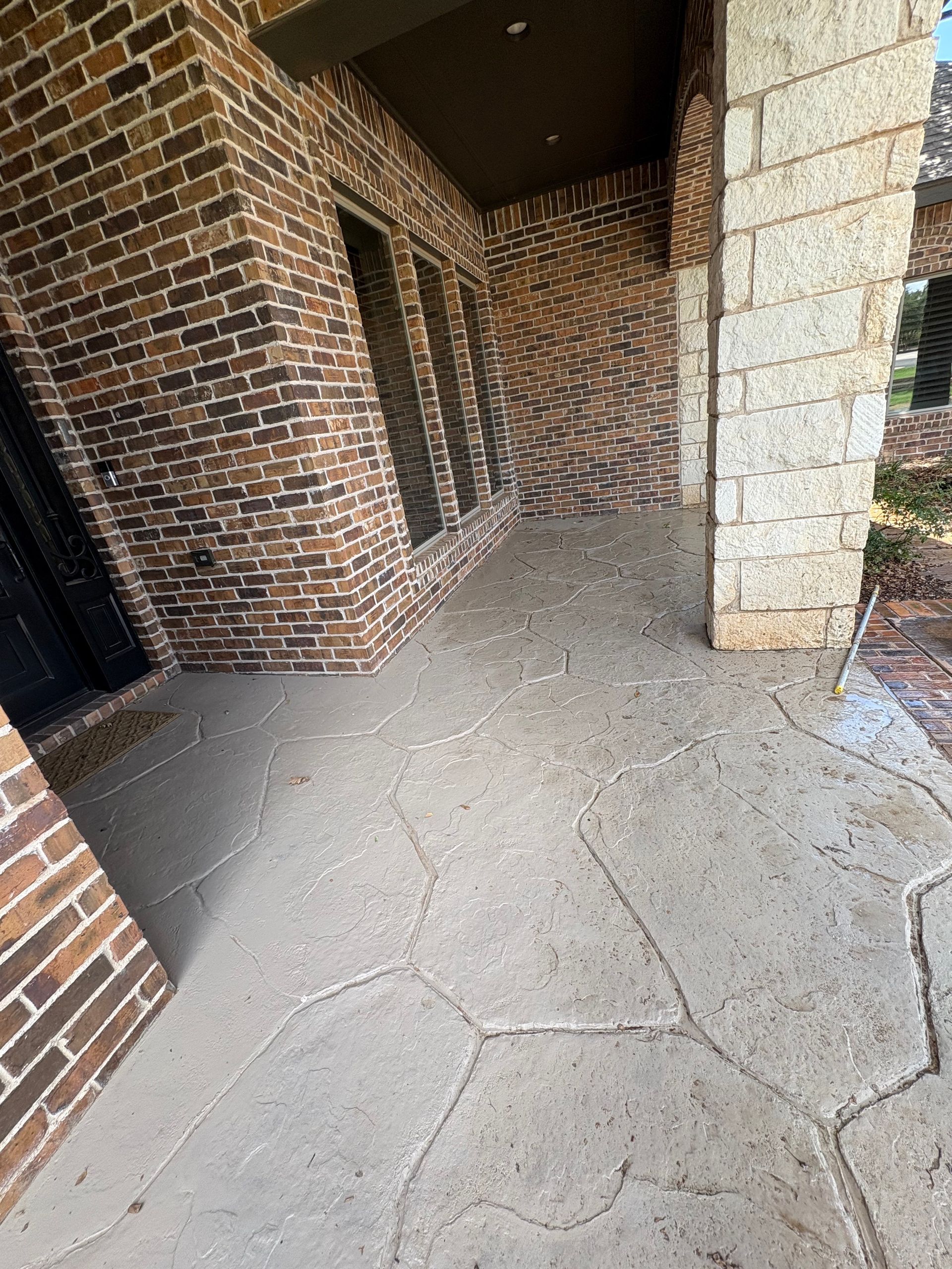 Brick building exterior with textured concrete porch.