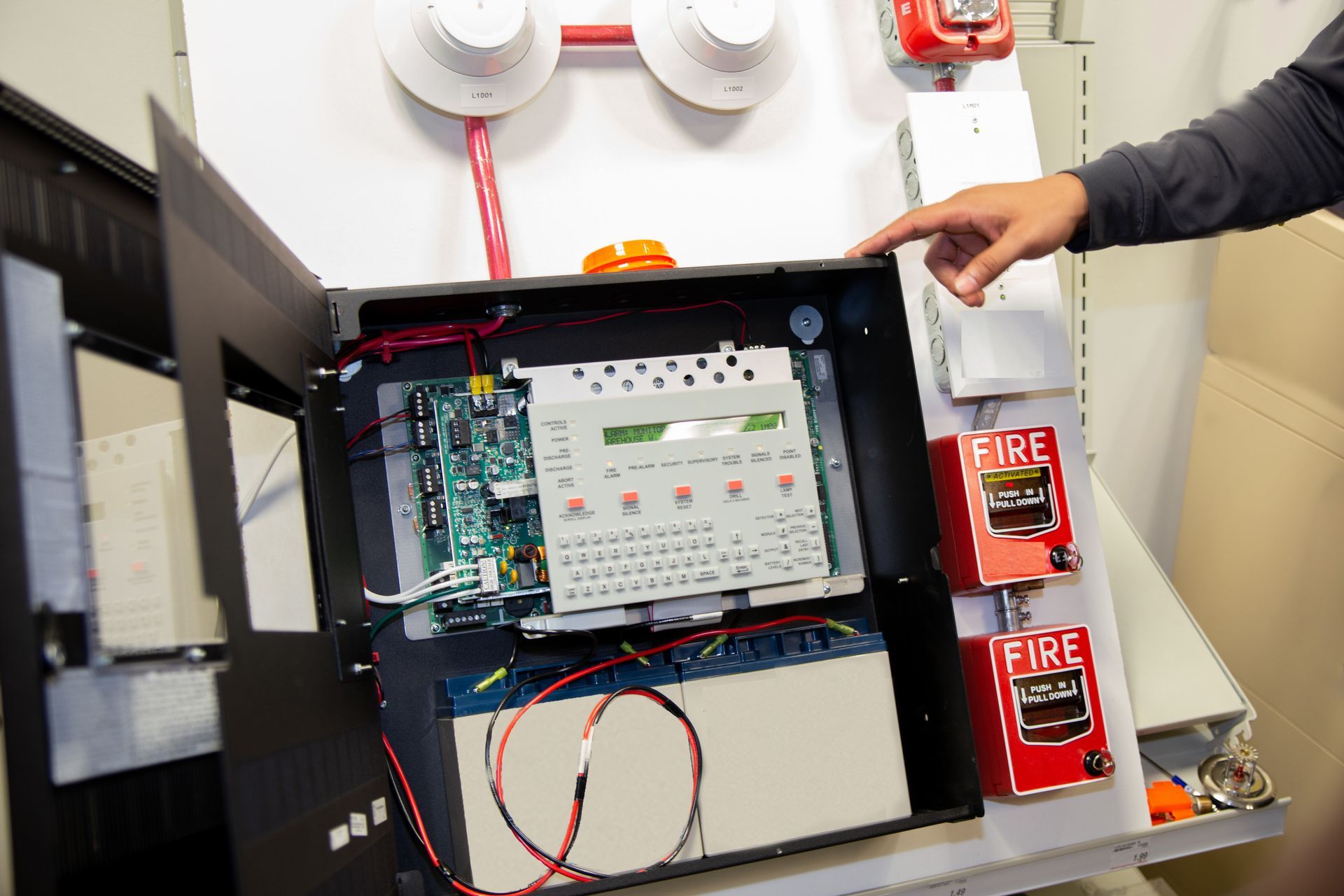 Fire alarm system attached to a white wall used for training.