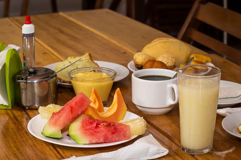 Uma mesa de madeira coberta com pratos de comida e bebidas.
