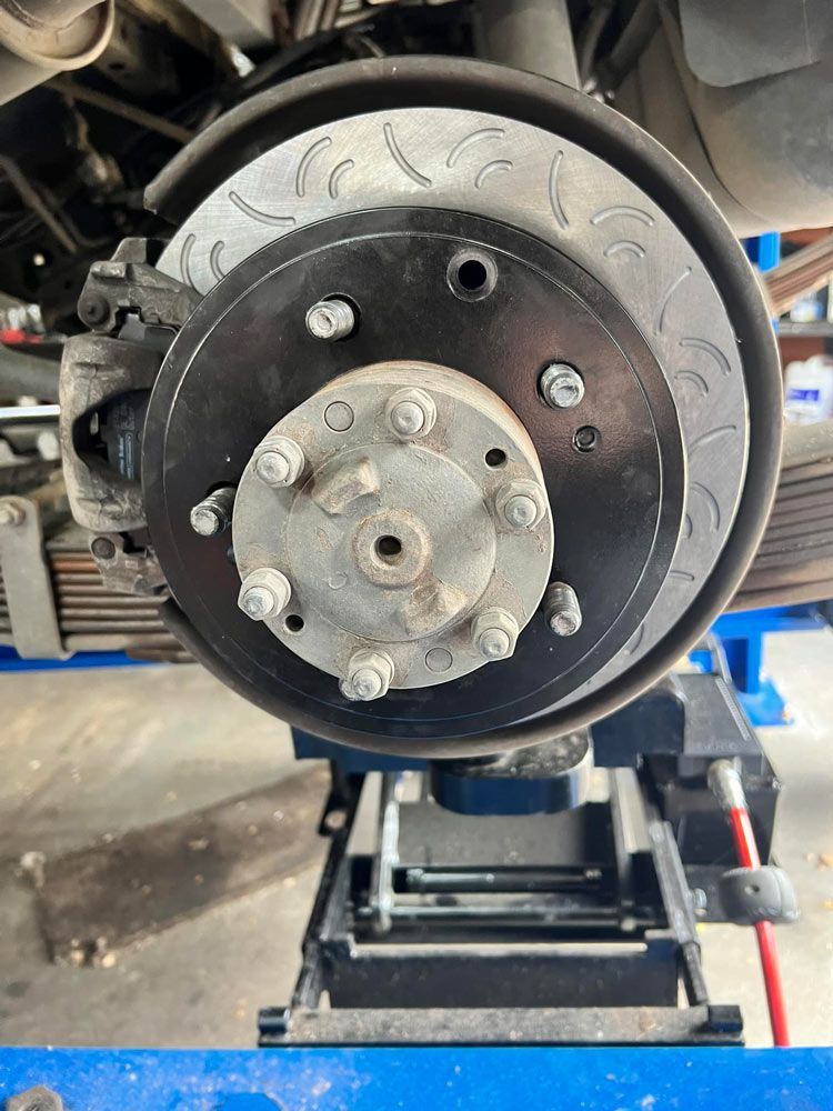 A Close Up Of A Brake Disc On A Car On A Lift — Licensed Mechanic in Albury, NSW