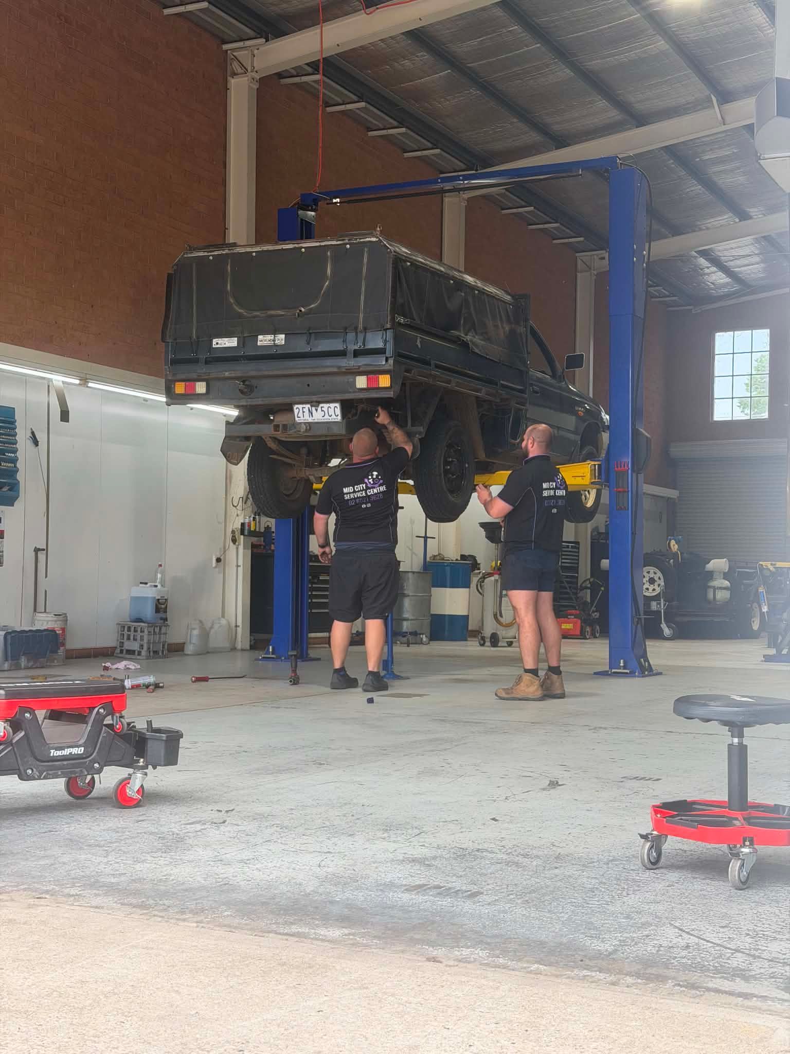 Car Mechanic In A Workshop Repairing A Vehicle — Rego Checks in Albury, NSW