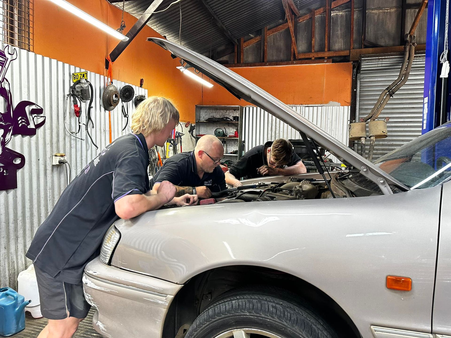 Three Mechanics Inspecting A Car Engine - Licensed Mechanic in Albury, NSW