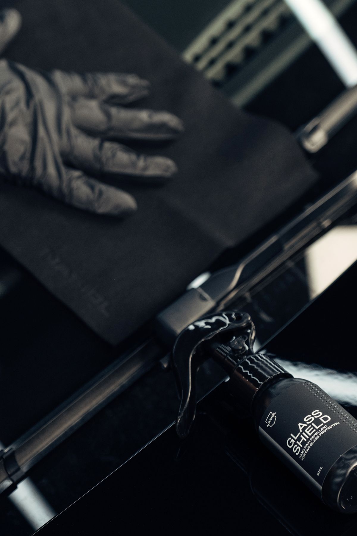 A person wearing black gloves is holding a black object