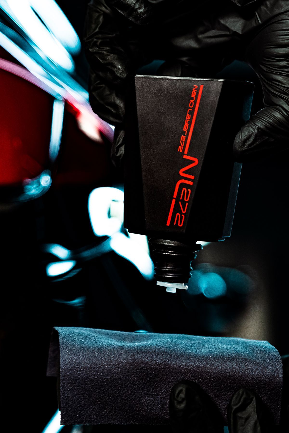 A person wearing black gloves is holding a bottle of ne22