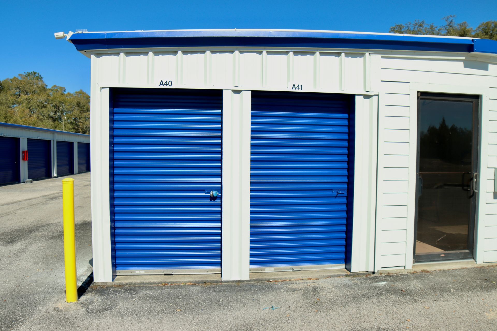 Blue storage units with white trim, numbers 203 and 204 are visible. A yellow pole is on the left.