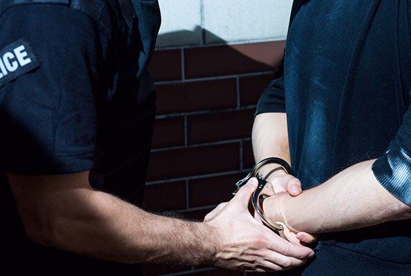 Police Officer Holding Man's Hands — St. Minneapolis, MN — Absolute Bail Bonds Police Officer Holding Man's Hands — St. Minneapolis, MN — Absolute Bail Bonds