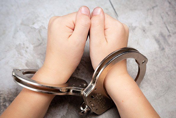 Hands Wearing Handcuffs — St. Minneapolis, MN — Absolute Bail Bonds Hands Wearing Handcuffs — St. Minneapolis, MN — Absolute Bail Bonds