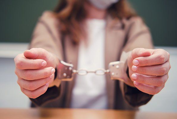 Close Up Of Woman Wearing Handcuffs — St. Minneapolis, MN — Absolute Bail Bonds Close Up Of Woman Wearing Handcuffs — St. Minneapolis, MN — Absolute Bail Bonds