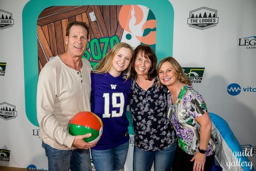 A group of people posing for a picture while one of them is wearing a jersey with the number 19 on it.