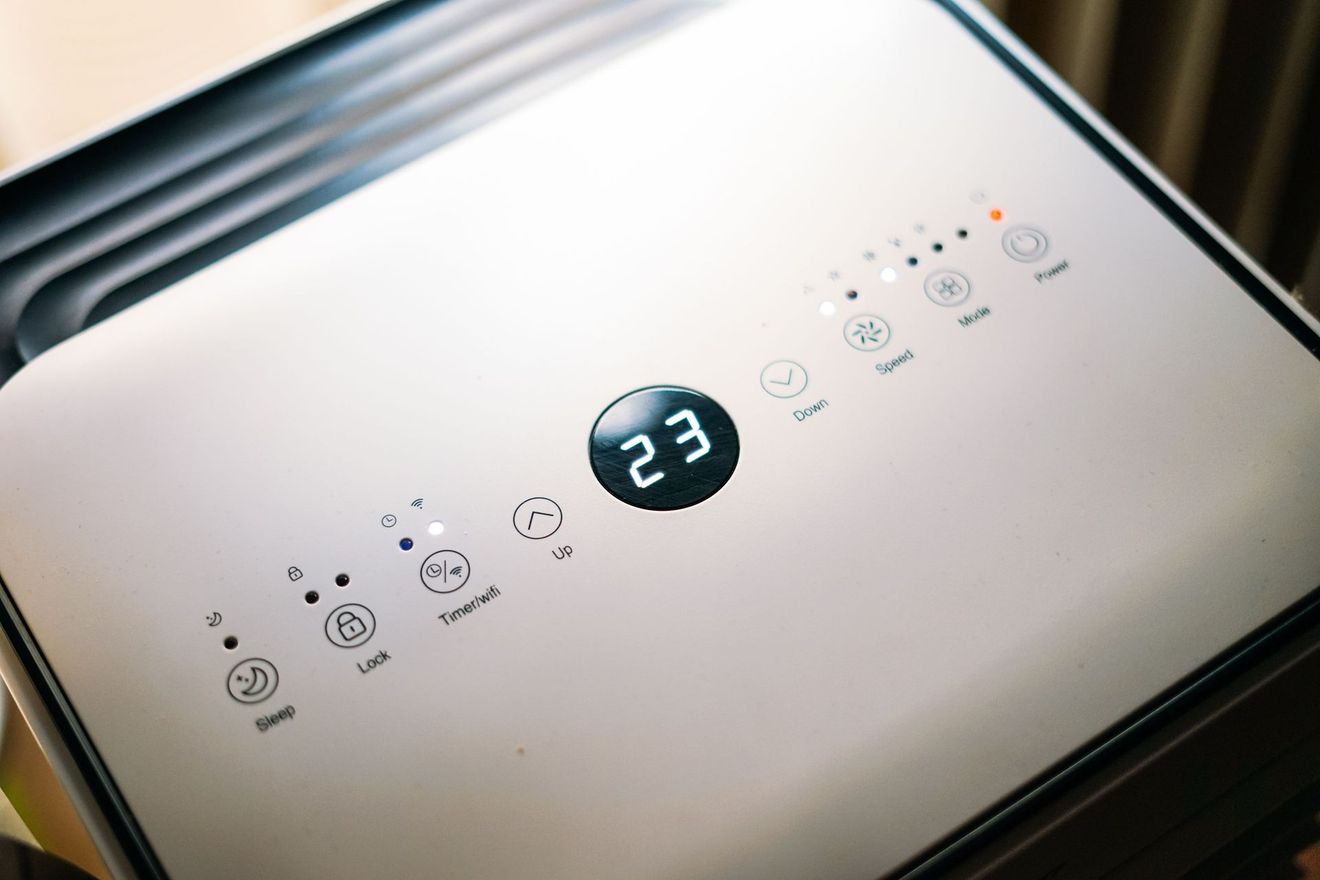 Top view of a white air purifier control panel with digital display and touch buttons