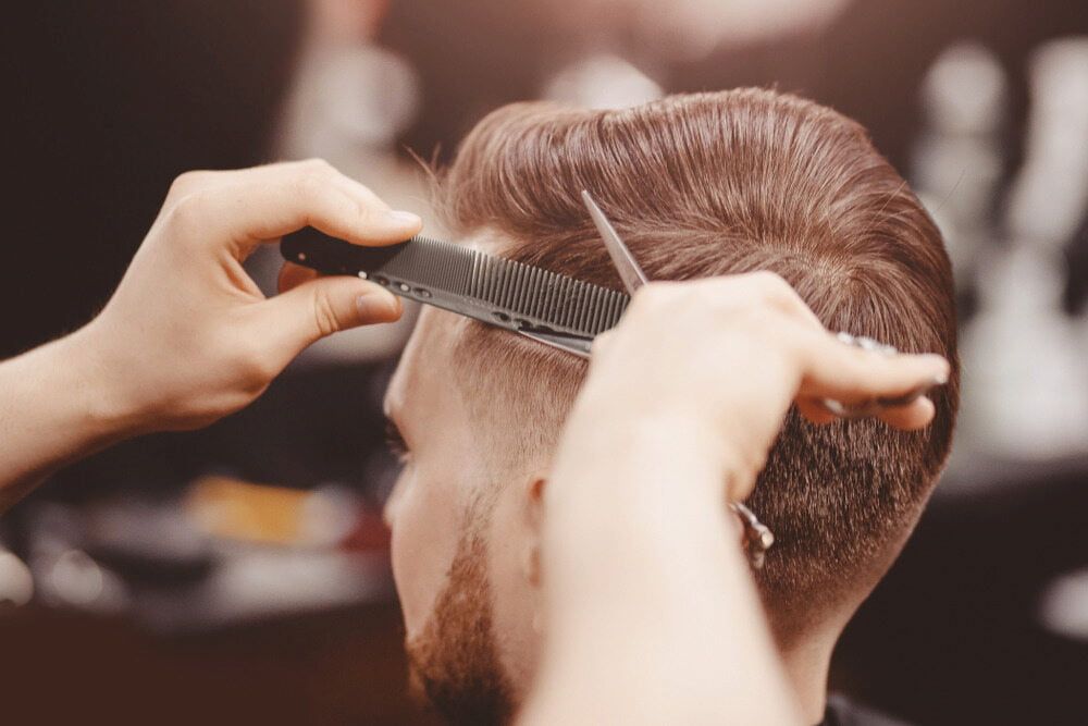Barber Cutting a Man's Hair With Comb and Scissors — Bermann Barbershop in Ngunnawal, ACT
