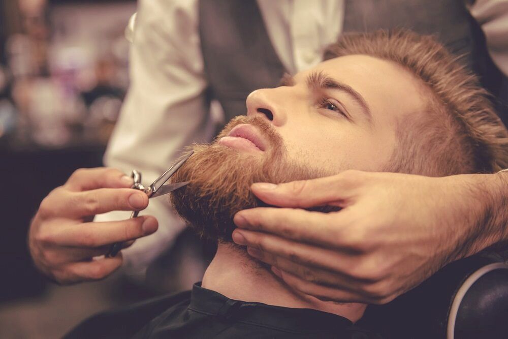 Barber Trimming a Man's Beard With Scissors — Bermann Barbershop in Casey, ACT