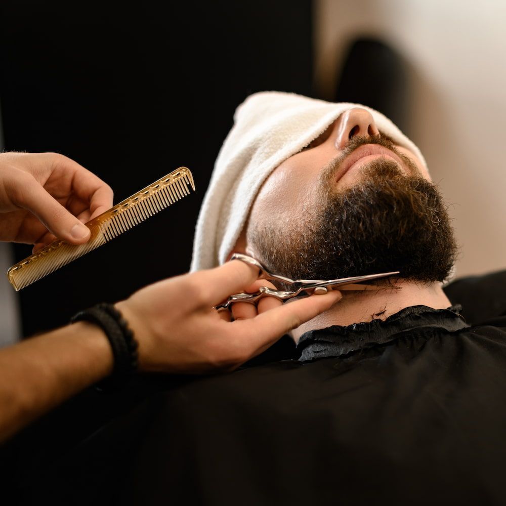 Barber Trimming a Man's Beard With Scissors and a Comb — Bermann Barbershop in Gungahlin, ACT