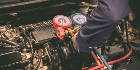 A man is working on the engine of a car.