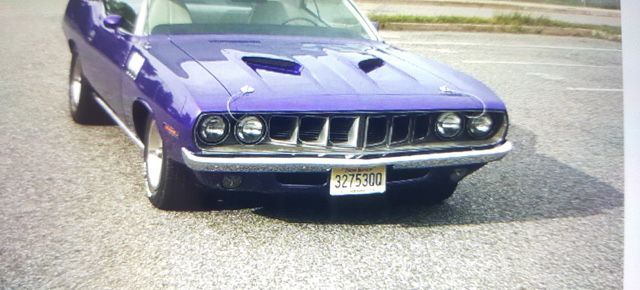 A purple car is parked on the side of the road.