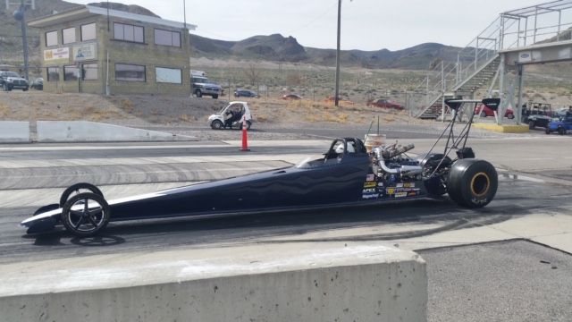 A black dragster is parked on the side of the road