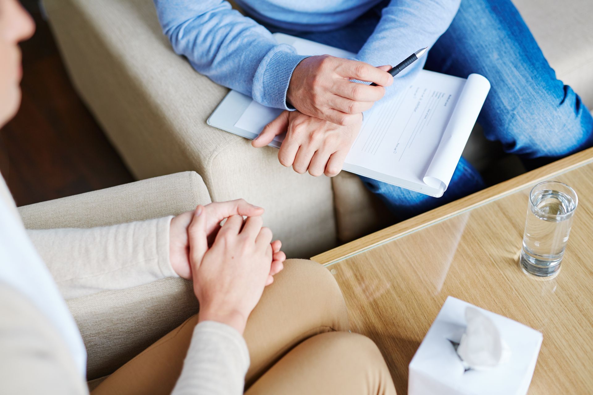 Close-up of a psychologist sitting next to his patient and listening to her story.
