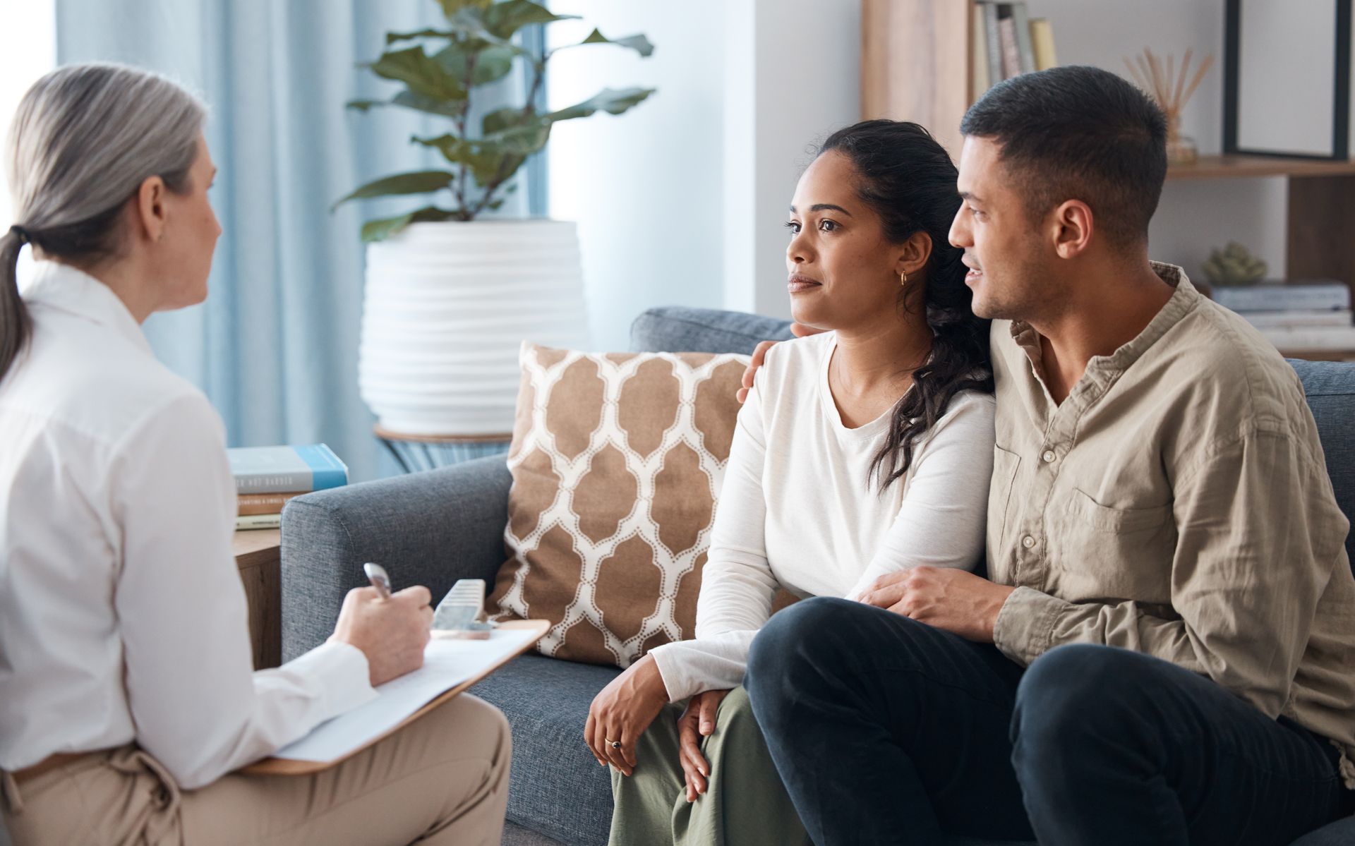 A couple on a sofa with a psychologist receiving marriage counselling. A couple on a sofa with a psychologist receiving marriage counselling.