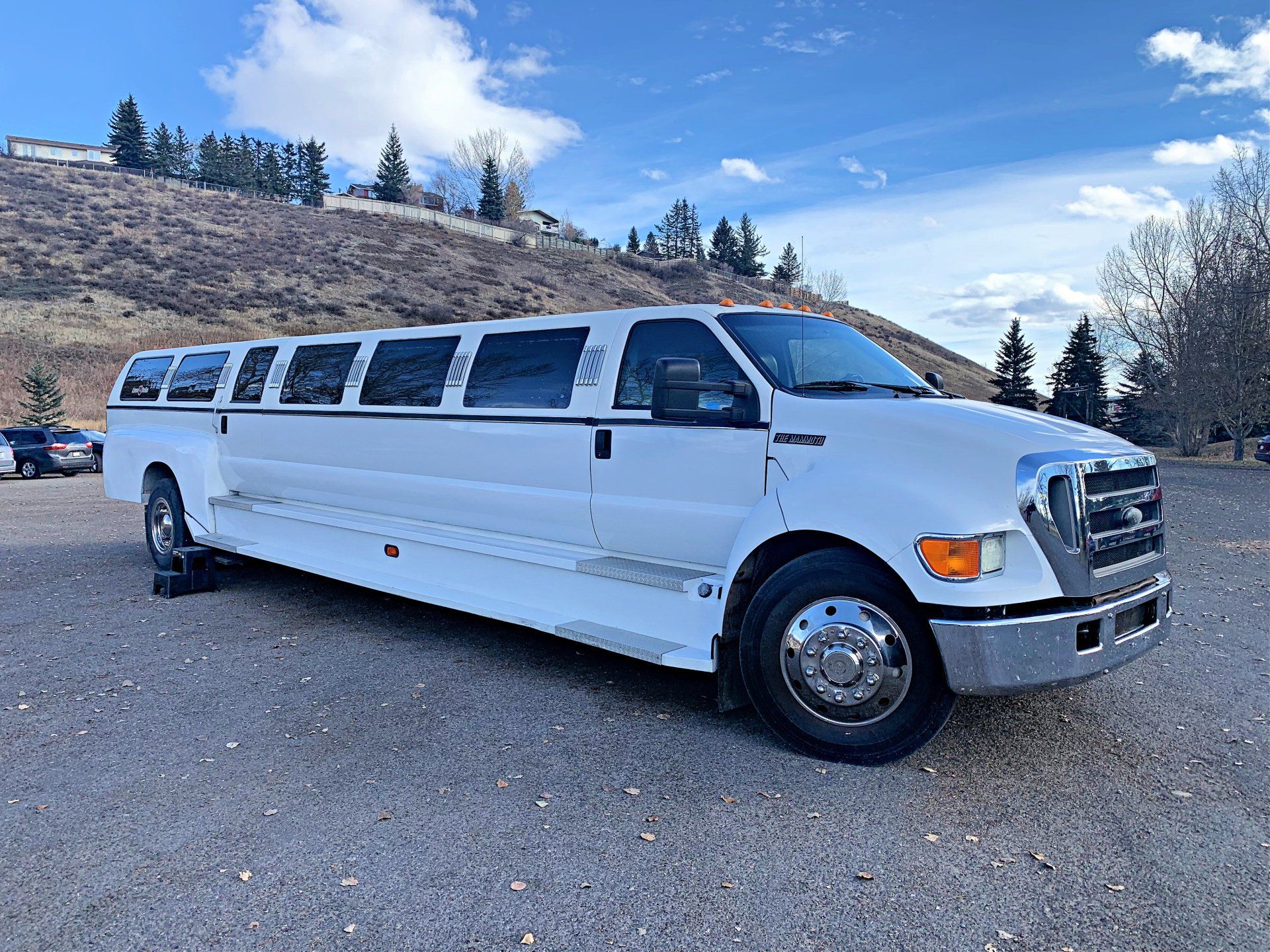 stretch truck limousine with hill backdrop