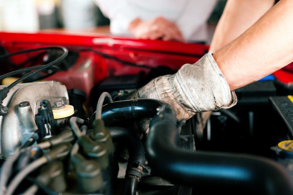 A Man Is Working On The Engine Of A Car — Cam Duffy Autos In Tolga, QLD
