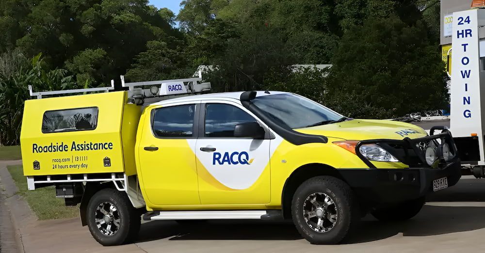 A Yellow Truck With The Word Racq On The Side Is Parked On The Side Of The Road — Cam Duffy Autos In Atherton, QLD