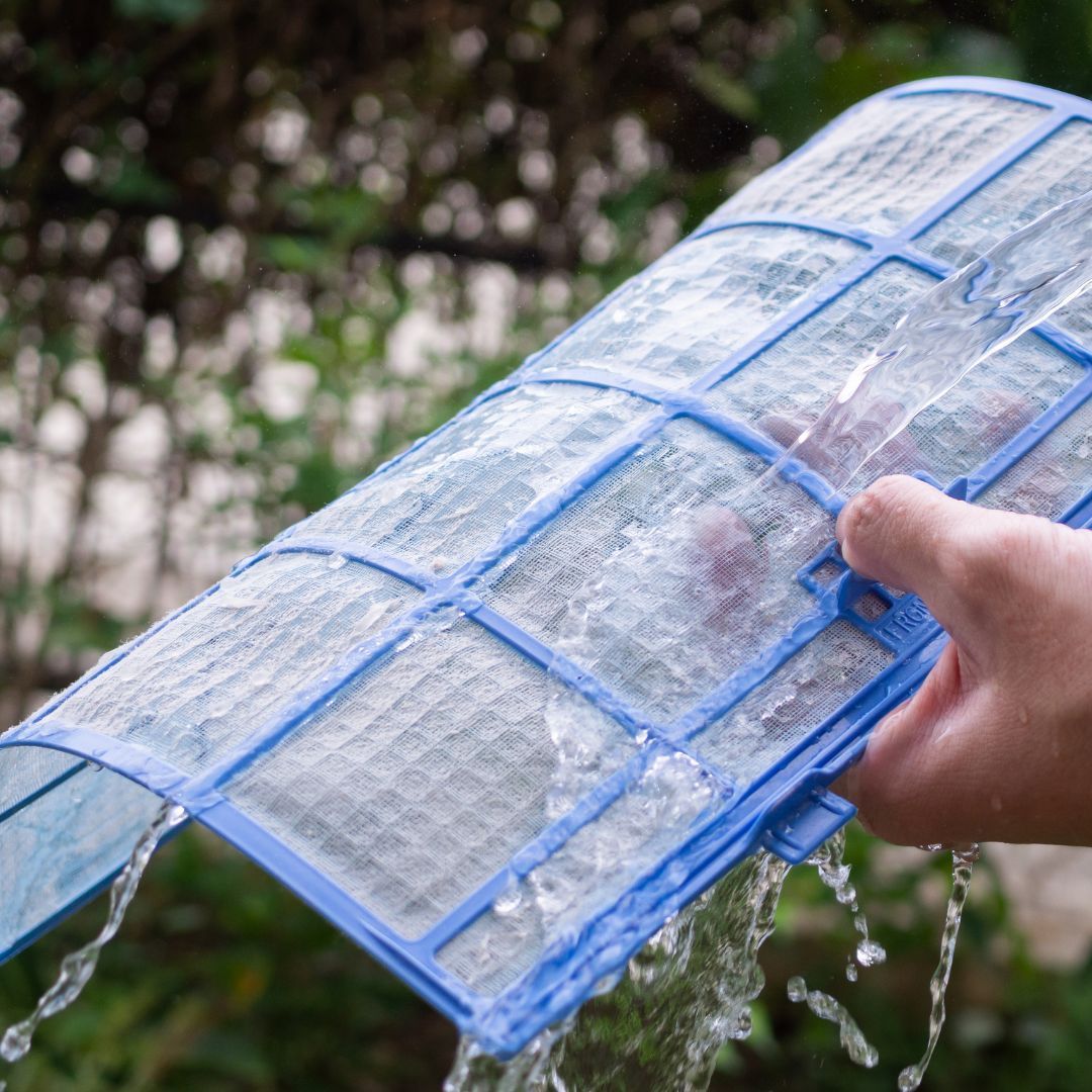A person is holding a blue filter with water coming out of it.