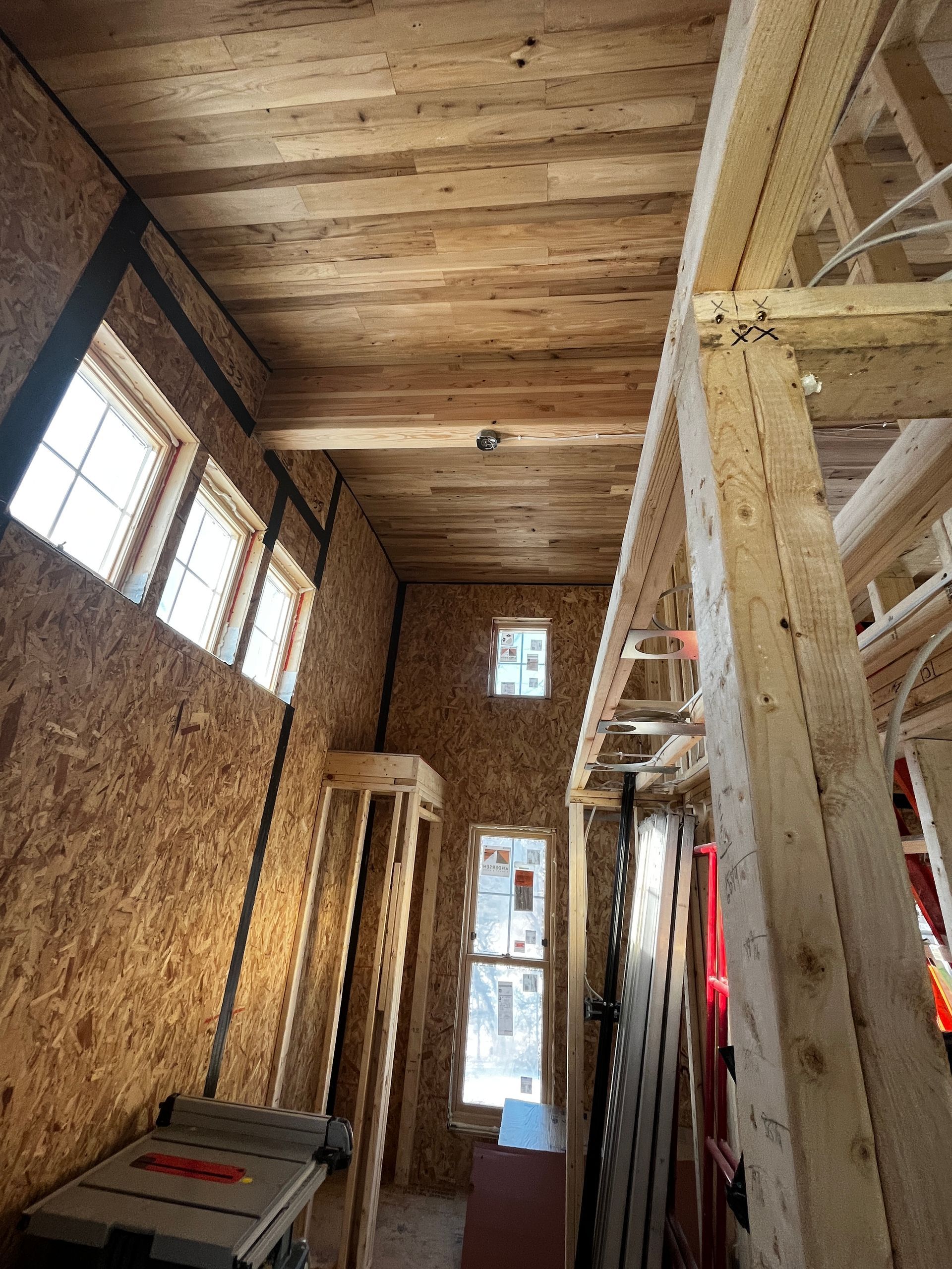 A room with a wooden ceiling and a table saw in it.