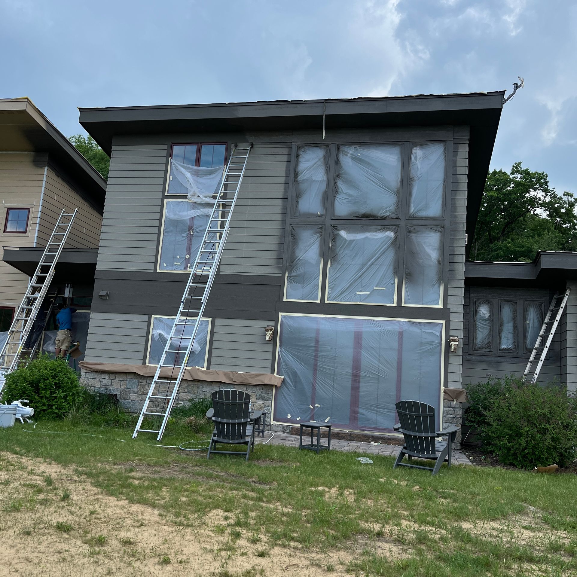 A house with a lot of windows is being painted