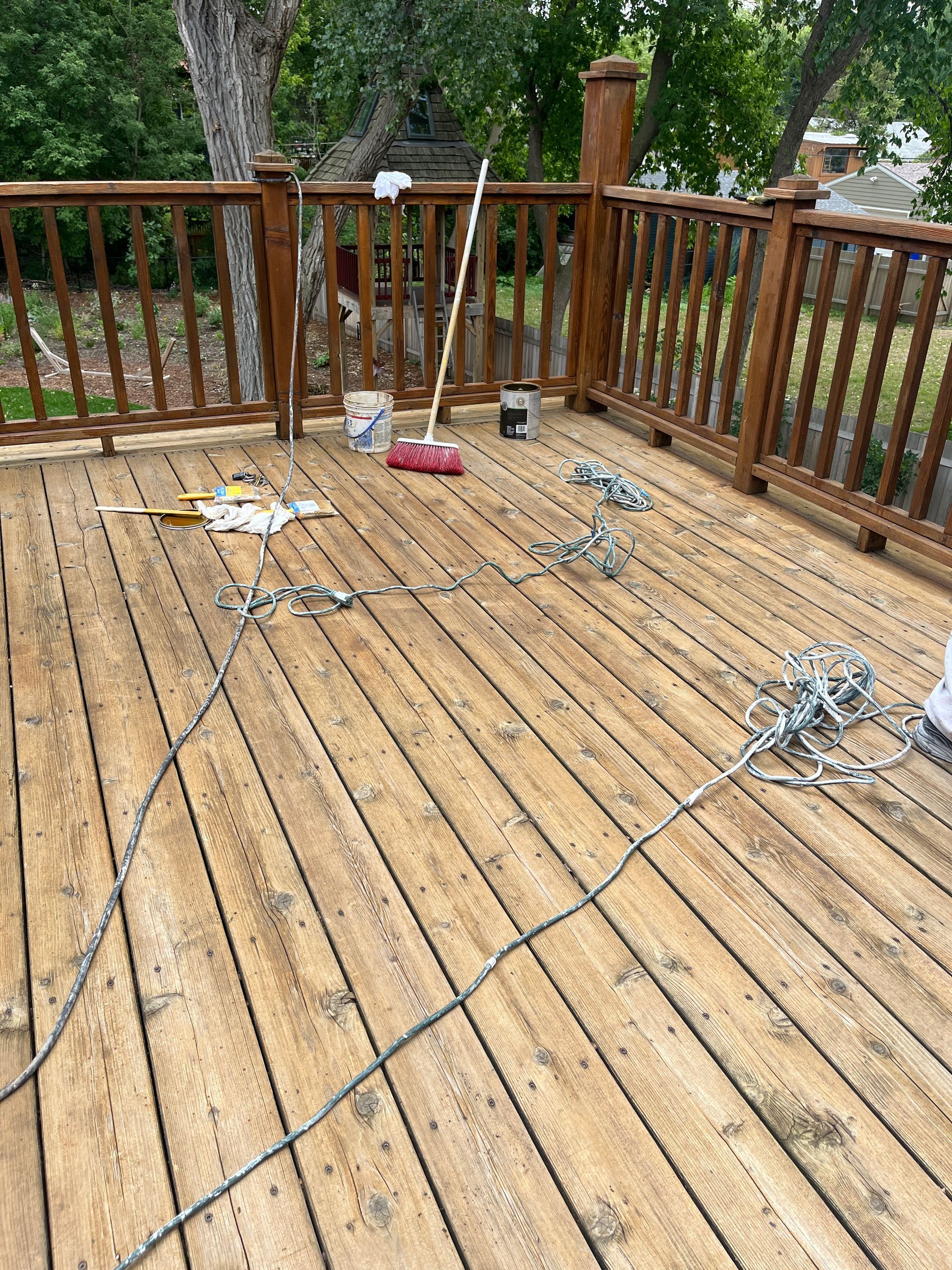 A wooden deck with a railing and tools on it.