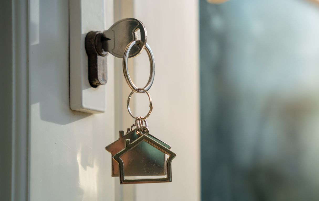 House key hanging in front door lock, symbolizing sell process and buy my house fast solution. House key hanging in front door lock, symbolizing sell process and buy my house fast solution.