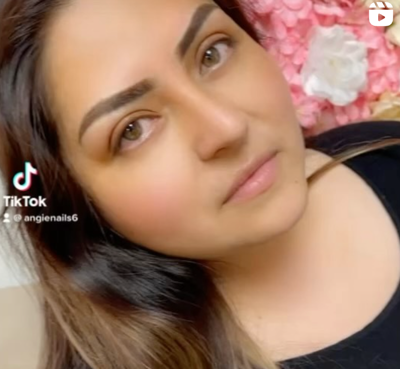 A close up of a woman 's face with flowers in the background.